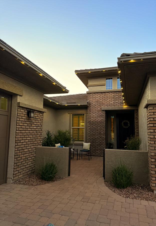 A courtyard entry at dusk with warm lights tucked under the eaves